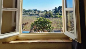 A window with a view of a rural landscape, including fields and trees. - Le Mas Golie (Le Castellet)