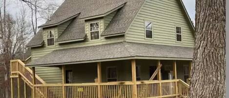 Stroll through the charming two-story house with a wooden porch and stone bases.