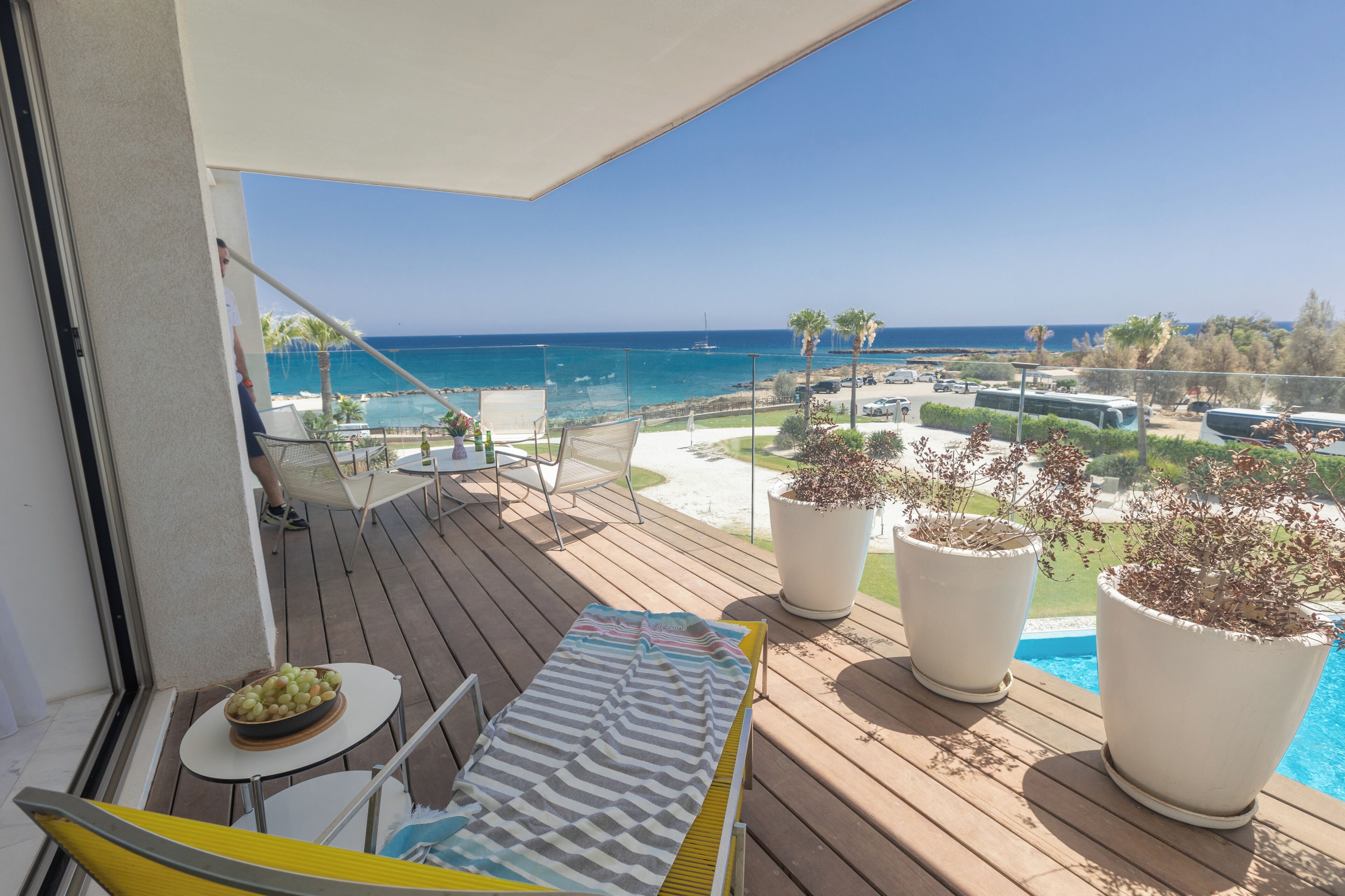 En balkon med havudsigt, en swimmingpool og plantekasser.