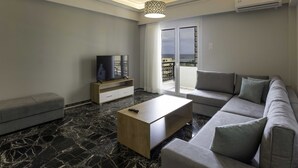 Een moderne woonkamer met een bank, een salontafel, een televisie en een balkon met uitzicht.