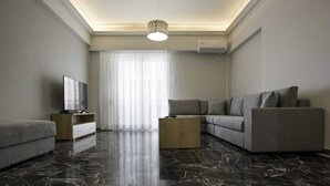 Een moderne woonkamer met een bank, een televisie en een salontafel.