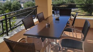 A balcony with a table and chairs, overlooking a scenic landscape. - Villa Stefanos, Sea View, Private Pool, Near Sea (Rethymno)