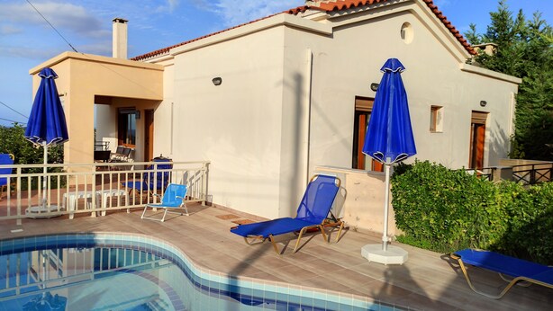 A poolside area with a swimming pool, blue lounge chairs, and umbrellas. - Villa Stefanos, Sea View, Private Pool, Near Sea (Rethymno)