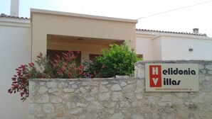 A stone wall with a sign for 'Helidonia Villas' and a website address. - Villa Stefanos, Sea View, Private Pool, Near Sea (Rethymno)