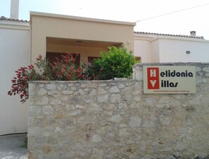 A stone wall with a sign for 'Helidonia Villas' and a website address. - Villa Stefanos, Sea View, Private Pool, Near Sea (Rethymno)