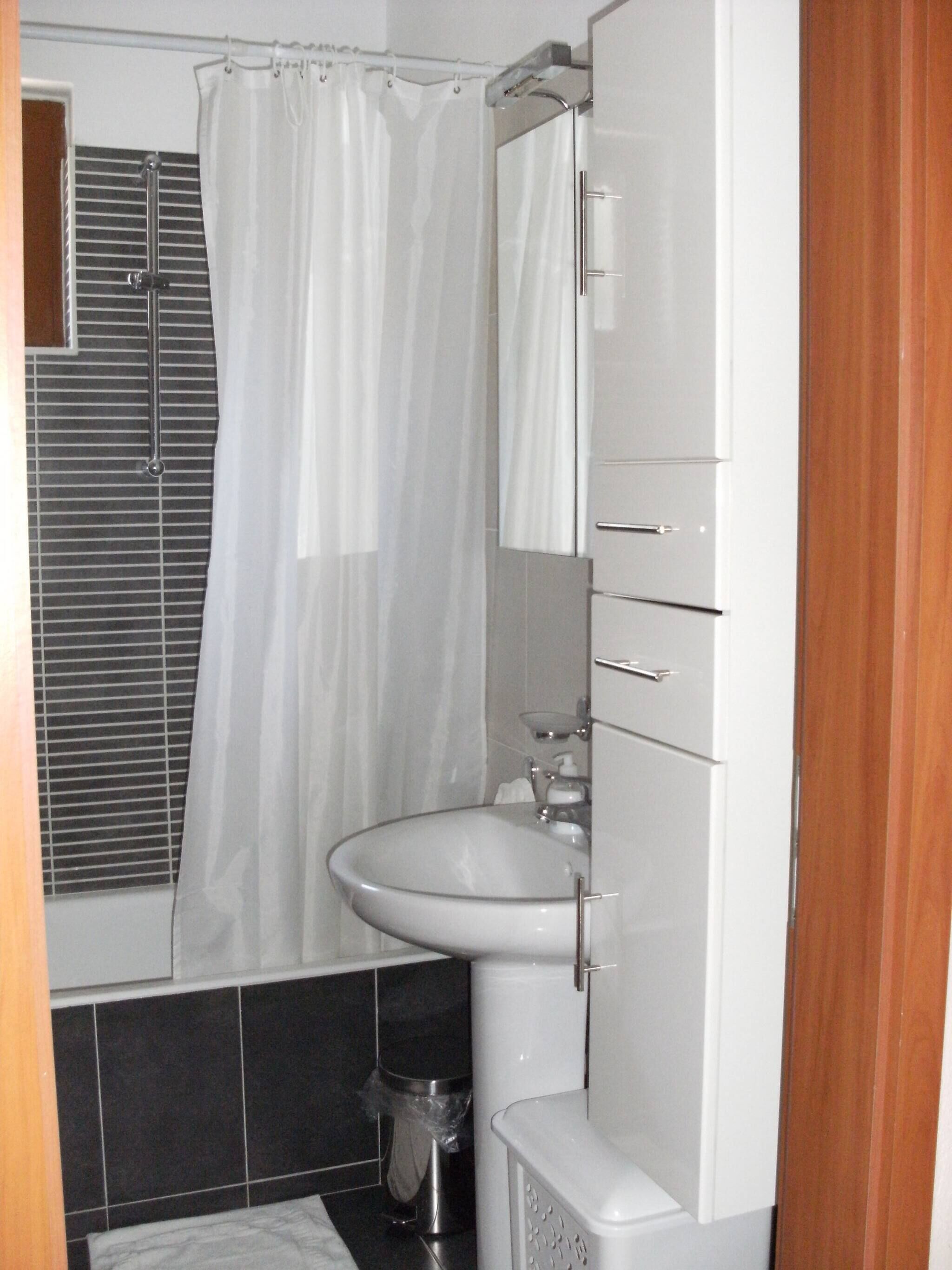 Un baño con ducha, lavamanos e inodoro.