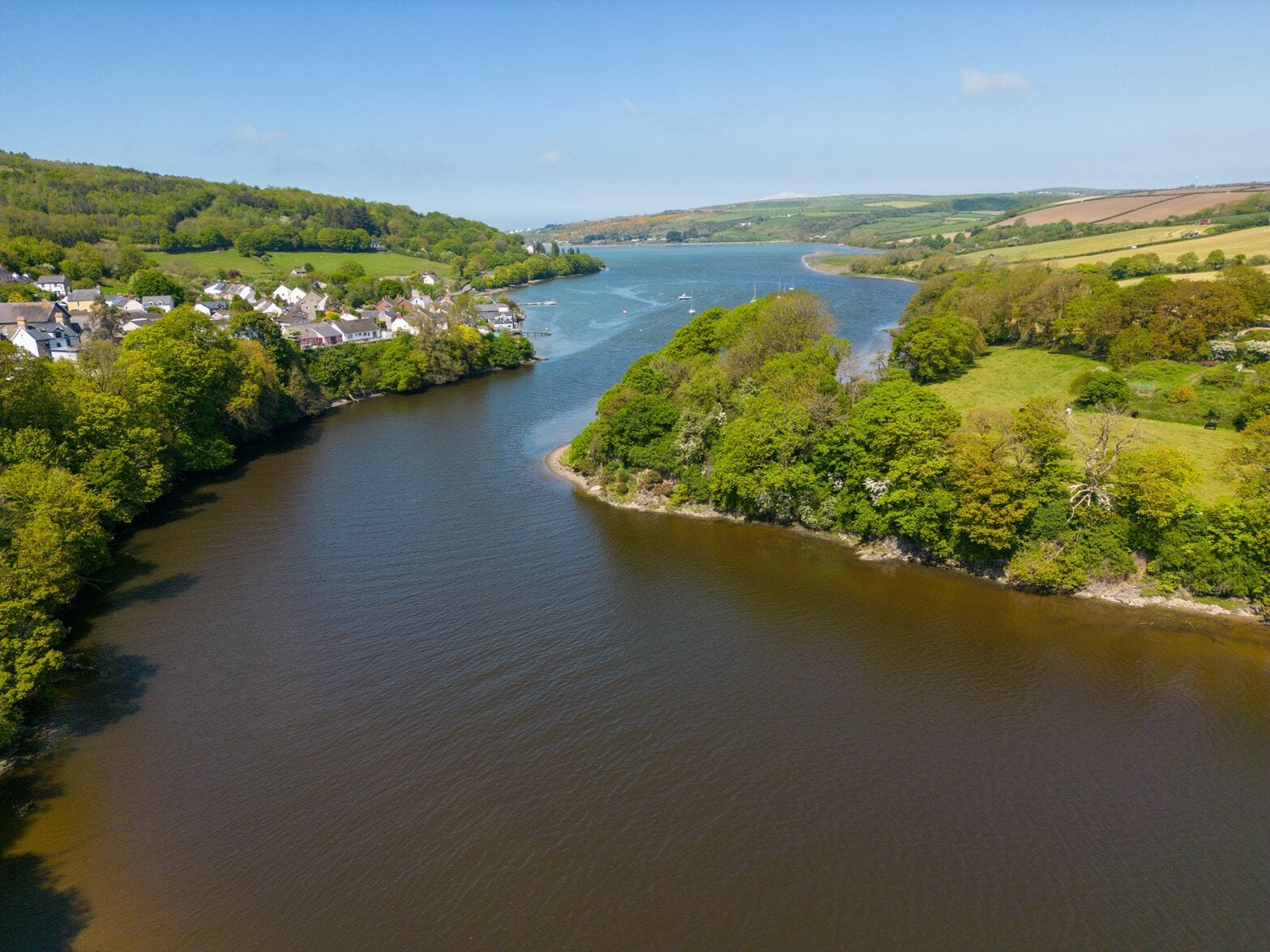 Ein Fluss schlängelt sich durch eine Stadt, entlang der Ufer reihen sich Häuser.