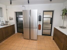 Una cocina con un refrigerador de acero inoxidable, un microondas y una tetera sobre la encimera.
