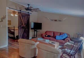 A living room with a television, a sofa, a coffee table, and two armchairs. - 2-bedroom house on 5 acres in delightful Smithville with cool AC breeze (Smithville)