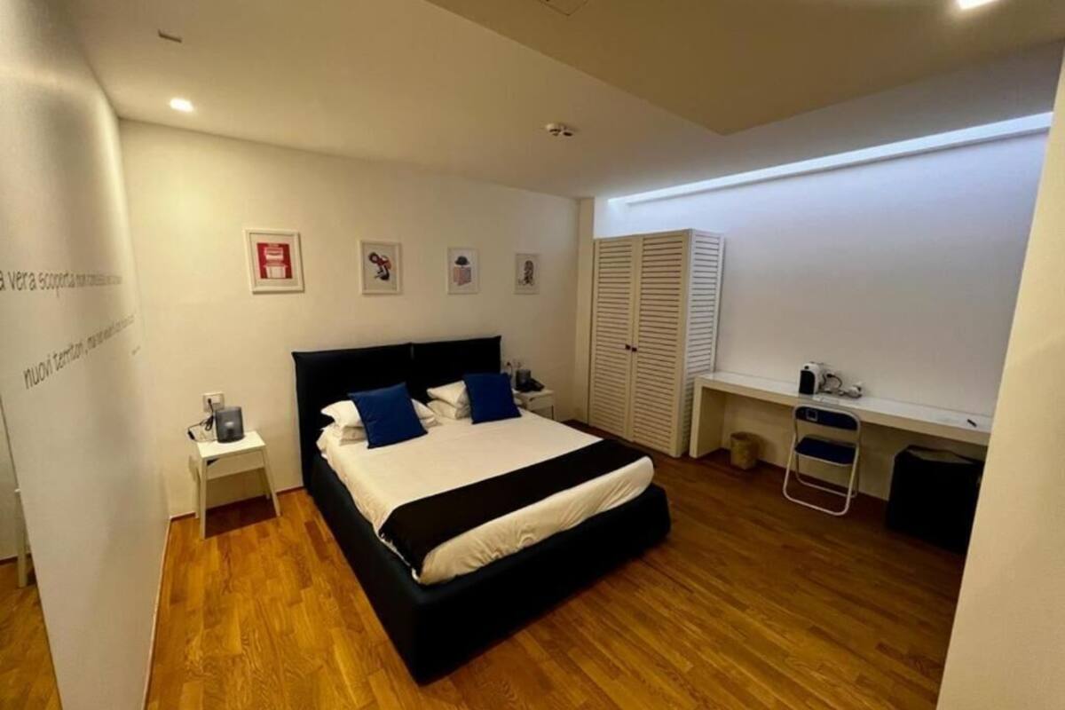 Une chambre à coucher comprenant un lit, des tables de chevet, un bureau et une armoire.