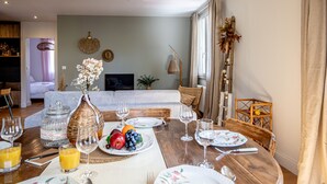 Un comedor con una mesa de madera preparada para una comida, rodeada de sillas.