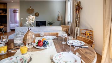 Ein Essbereich mit einem Holztisch, der für eine Mahlzeit gedeckt ist, umgeben von Stühlen.