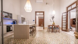 A modern kitchen with a central island, pendant lighting, and a patterned floor. - The Horseshoe - spacious pool & sunset roof terrace (Mérida)
