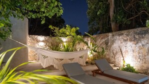 A hammock and two lounge chairs in an outdoor setting with a stone wall and plants. - The Horseshoe - spacious pool & sunset roof terrace (Mérida)
