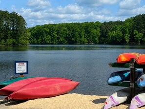 A lakeside view with a sign indicating a life jacket rental station. - 2BR · High Point · Hickswood Townhome (High Point)