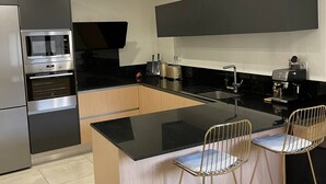 A modern kitchen with a central island, stainless steel appliances, and a minimalist design.