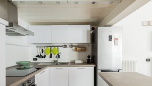 Een moderne keuken met witte kasten, een roestvrijstalen spoelbak en een inbouwoven.