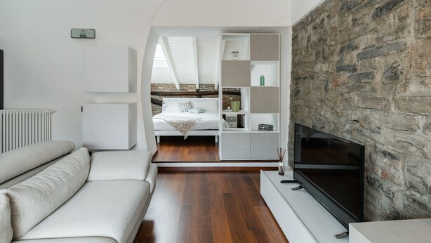 Een moderne woonkamer met een stenen openhaard, een flatscreen televisie en een comfortabele bank.