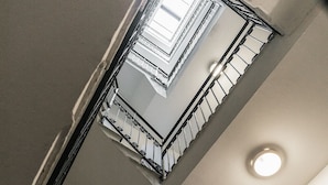 Een wenteltrap met gedetailleerde metalen balustrades en uitzicht op de bovenverdieping.