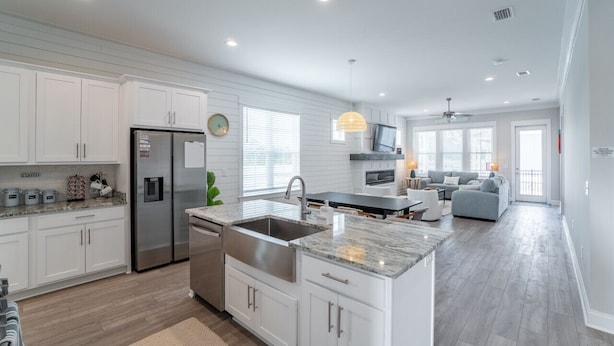 A modern kitchen with white cabinetry, stainless steel appliances, and a central island. - Luxury 4BR/4BA Beach Retreat Game Room, Resort Pool, & Prime Location (Orange Beach)