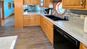 A kitchen with wooden cabinets, a dishwasher, and a countertop.