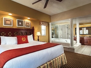 Relax in this inviting space with a large bed, wooden headboard, and a nightstand with a lamp.