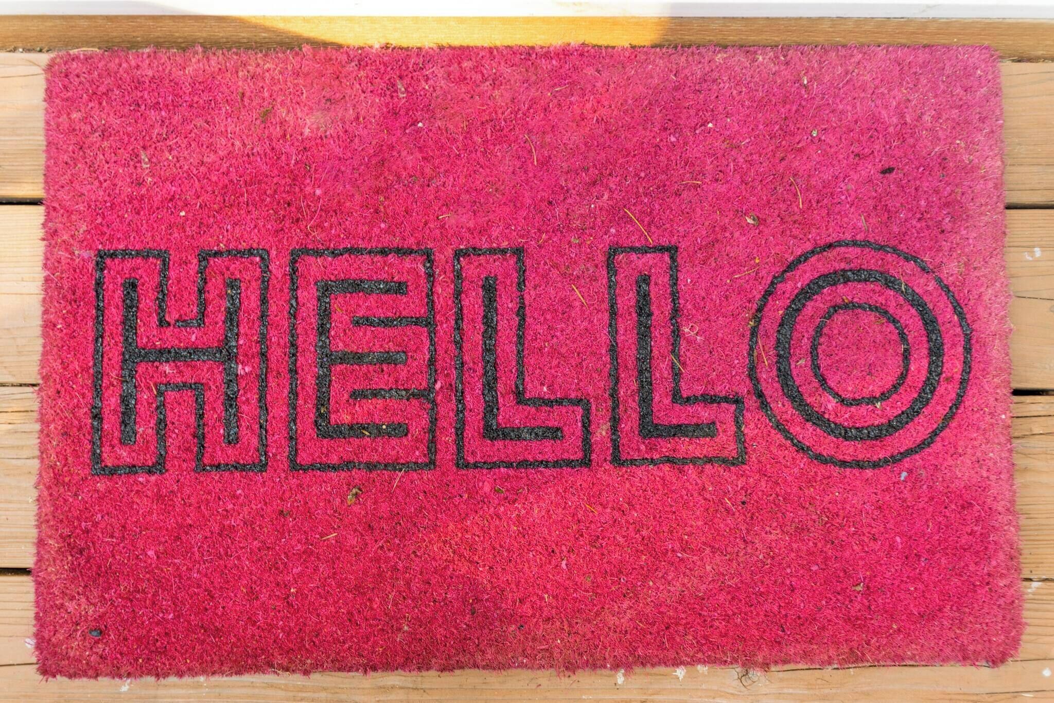 A red doormat with the word 'HELLO' in black letters.