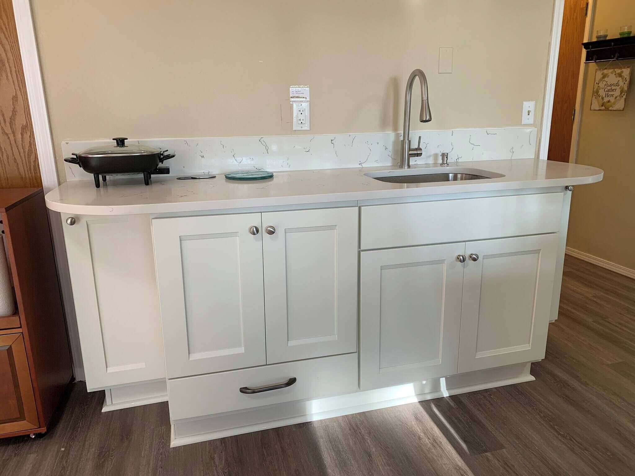 A kitchen with a sink, a stove, and cabinets.