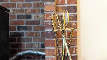 A brick wall, a metal bucket, and a brass tool stand.