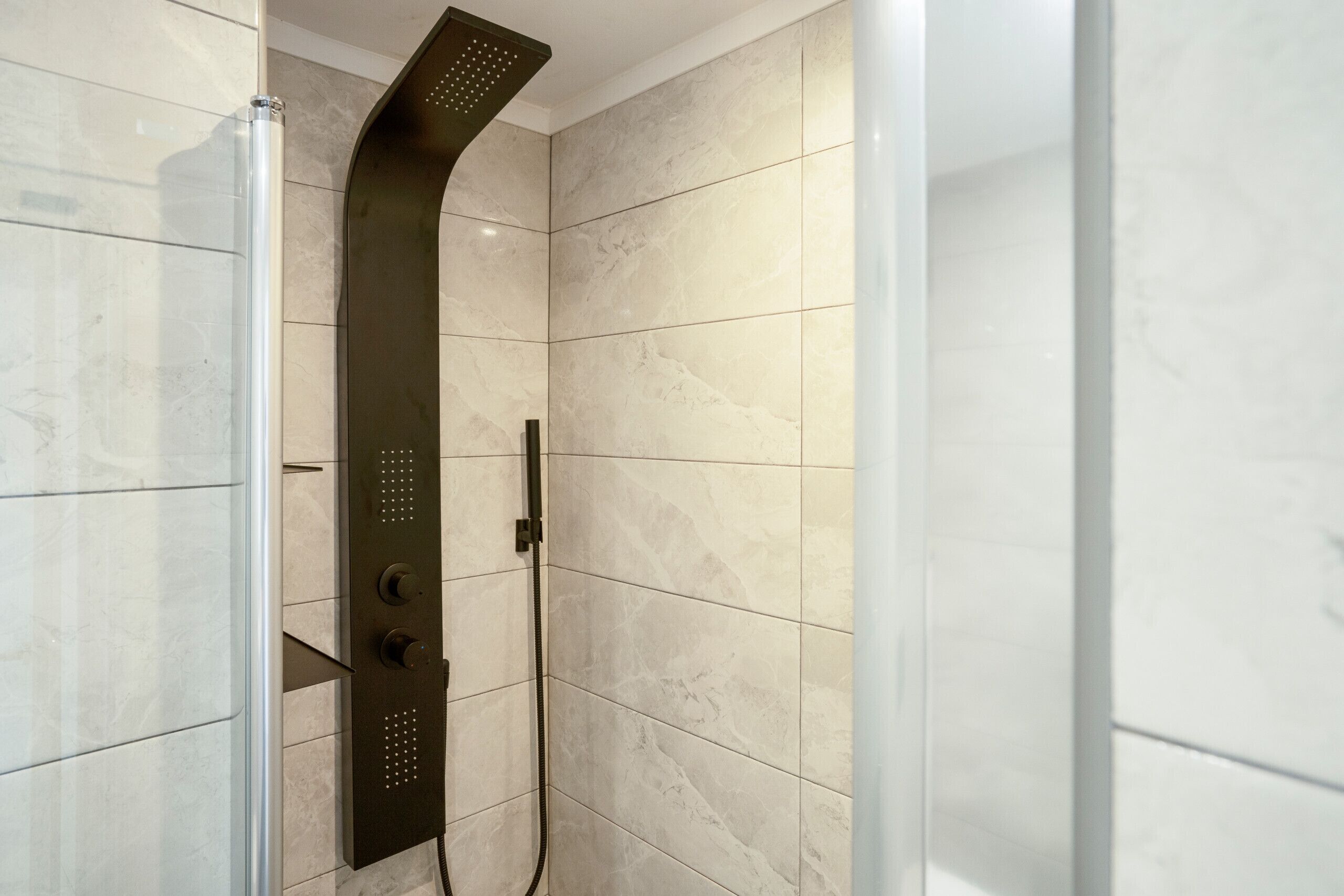 Una ducha moderna con diseño curvo y panel de control.