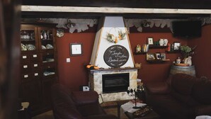 A cozy living room with a fireplace, leather sofas, a wooden cabinet with glass doors, and a stone wall. - " il Rifugio di Aitna " (Ragalna)