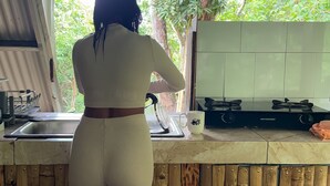 A woman standing at a kitchen counter with a view of greenery outside. - Aqeel Cabin in Nature and River (Churuquita Grande)