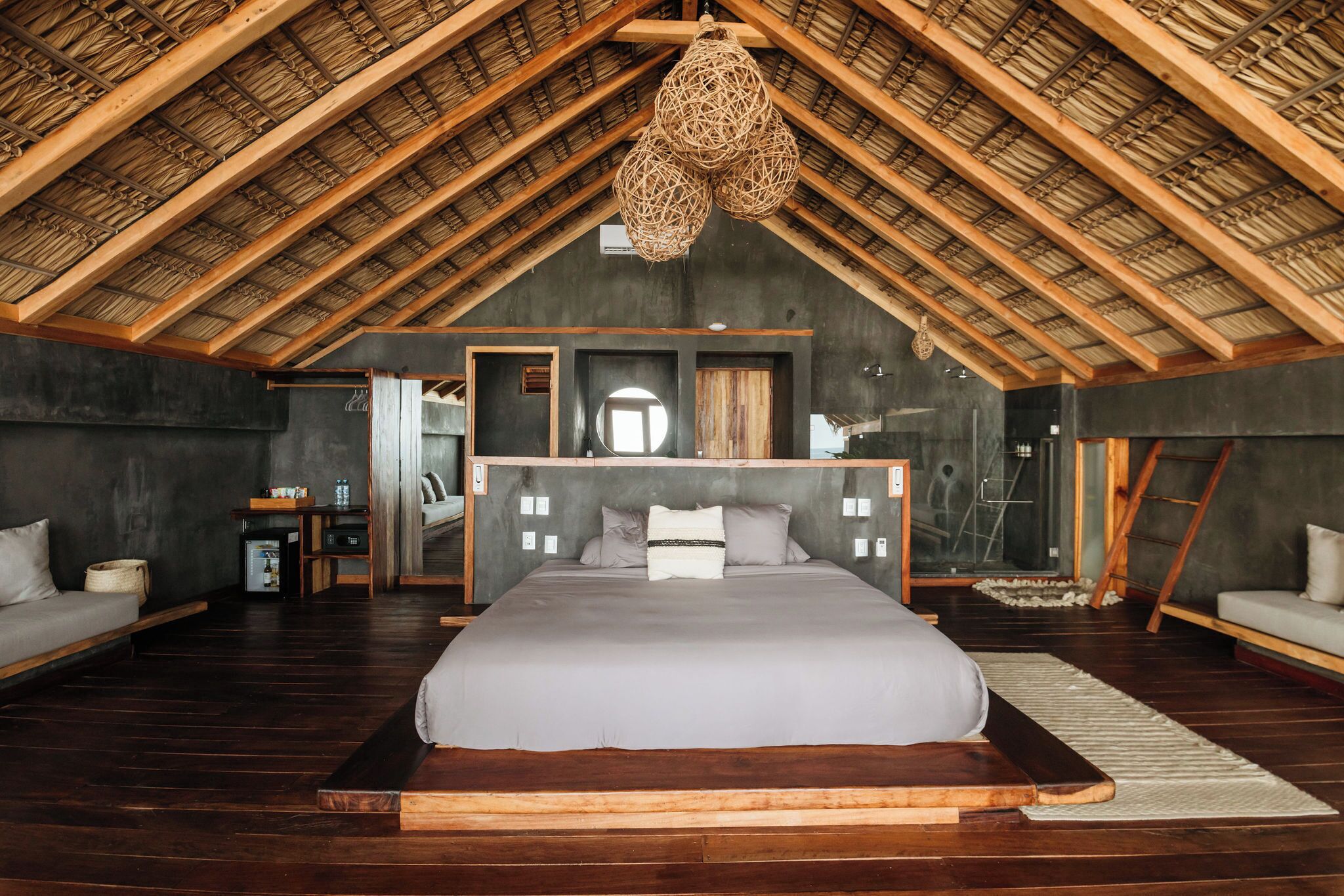 A spacious bedroom with a large bed, a wooden ceiling, and a modern design.