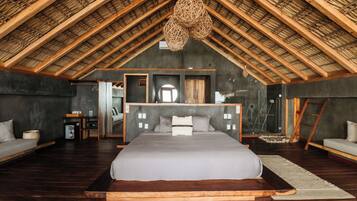 A spacious bedroom with a large bed, a wooden ceiling, and a modern design.