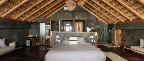 A spacious bedroom with a large bed, a wooden ceiling, and a modern design.