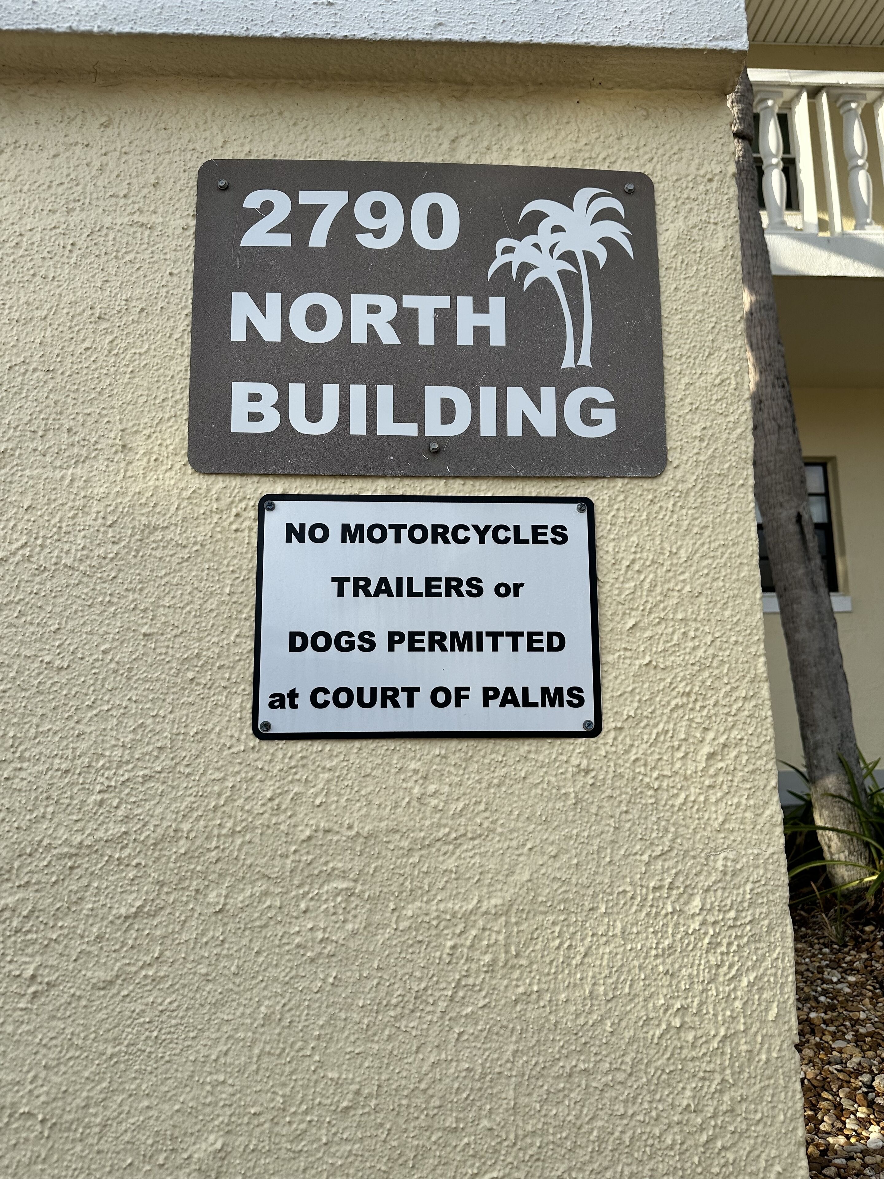 Ein Gebäudeschild mit der Adresse '2790 NORTH BUILDING' und einem Schild, das das Parken von Motorrädern, Anhängern oder Hunden untersagt.