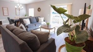 Ein Wohnzimmer mit einer Couch, einem Couchtisch und einer Topfpflanze.