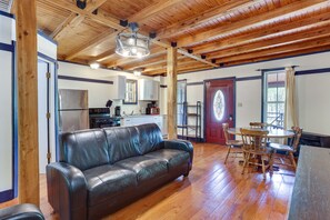 Relax in this spacious living area with a high ceiling, featuring a leather sofa and dining table.