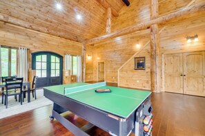 A wooden interior with a ping pong table, chairs, and a door. - Gatlinburg Vacation Rental w/ Private Hot Tub! (Gatlinburg)