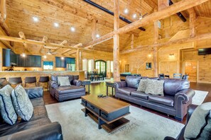 A spacious log cabin interior with a dining area, kitchen, and seating area. - Gatlinburg Vacation Rental w/ Private Hot Tub! (Gatlinburg)