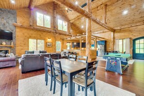 A spacious log cabin interior with a dining area, sofa, kitchen, and pool table. - Gatlinburg Vacation Rental w/ Private Hot Tub! (Gatlinburg)