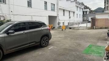 A parking area with a car and a building in the background.