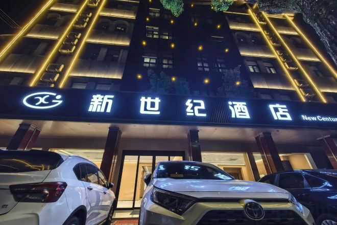 Ein Hotel Eingang mit beleuchteter Beschilderung und parkenden Autos.