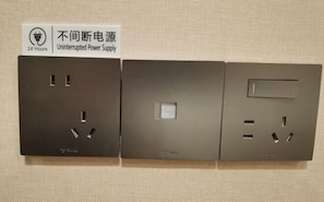 Three wall-mounted electrical outlets with a sign indicating a 24-hour uninterrupted power supply. - Shitai New Century Hotel (Shitai)