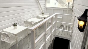 A white interior with a staircase, a table with chairs, and a potted plant. - Central Economic Stavanger (Stavanger)
