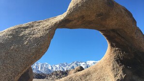 A natural rock arch formation with a mountainous backdrop. - RV Site #15 near Death Valley (Olancha)