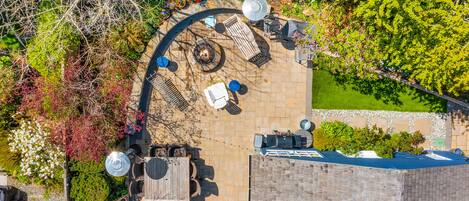 Une terrasse extérieure avec un foyer, des sièges et une petite piscine.