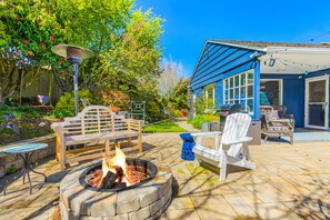A patio with a fire pit, outdoor furniture, and a garden. - Magnolia on the Hill (Seattle)