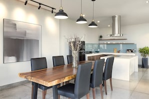 A modern kitchen with a central island, pendant lighting, and a large abstract painting on the wall. - Spacious 1bdr Perfect For Romantic Weekend Seaview (Da Nang)