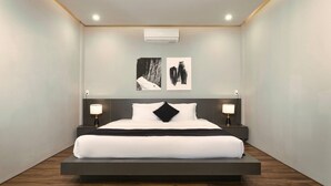 A modern hotel room with a minimalist design, featuring a large bed, two bedside tables with lamps, and artwork on the wall. - Spacious 1bdr Perfect For Romantic Weekend Seaview (Da Nang)